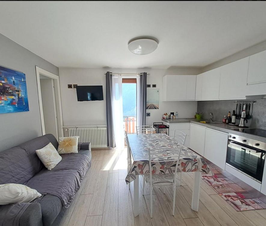 a kitchen and living room with a table and a couch at Villetta Col Ranzola in Brusson