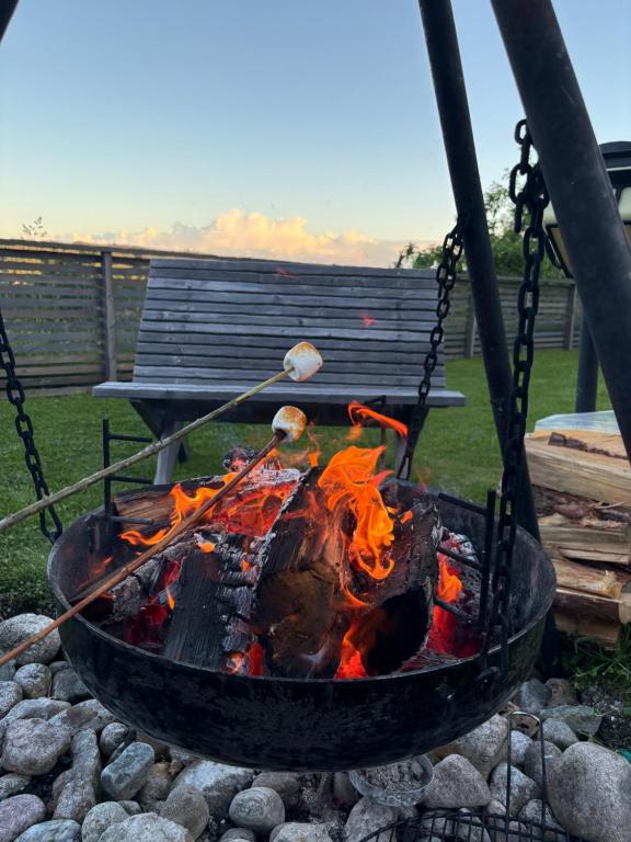 a fire pit with a grill with a fire at Leilighet på RyenToppen med gapahuk in Kristiansand