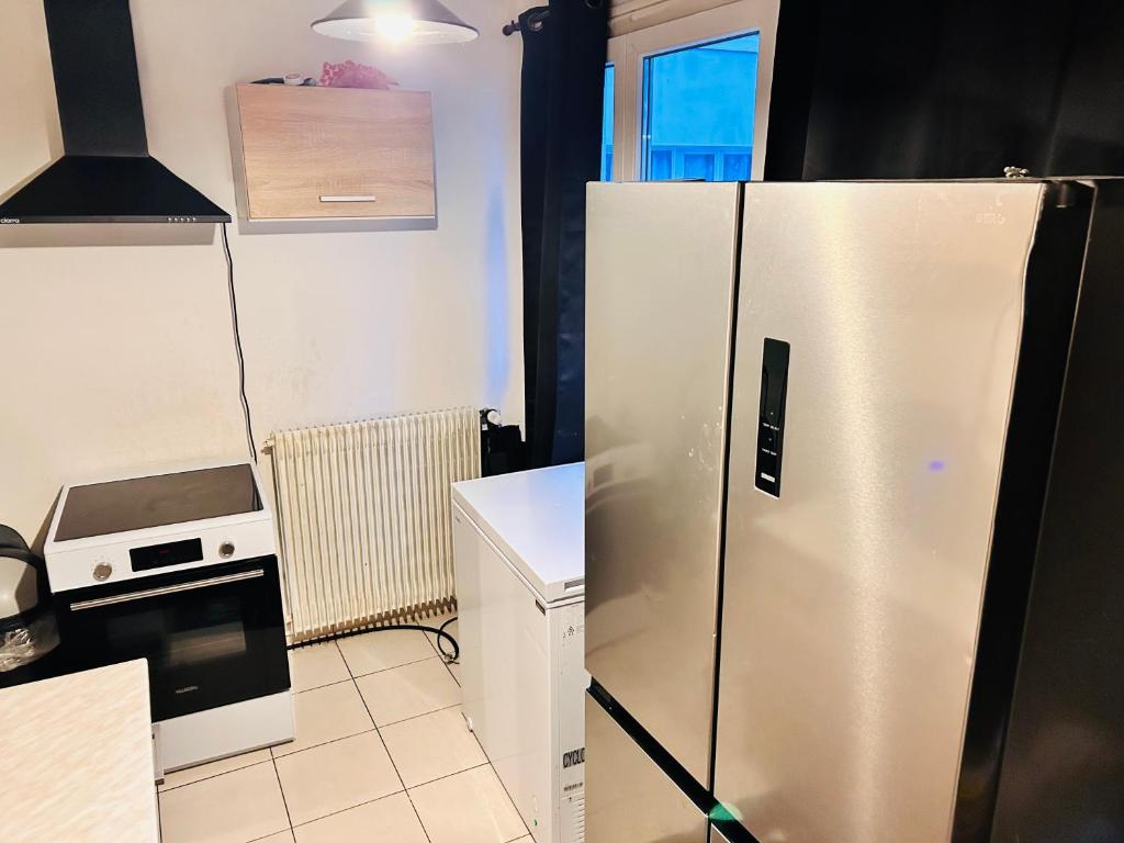 a kitchen with a refrigerator and a microwave at Val hôtel in Courcouronnes