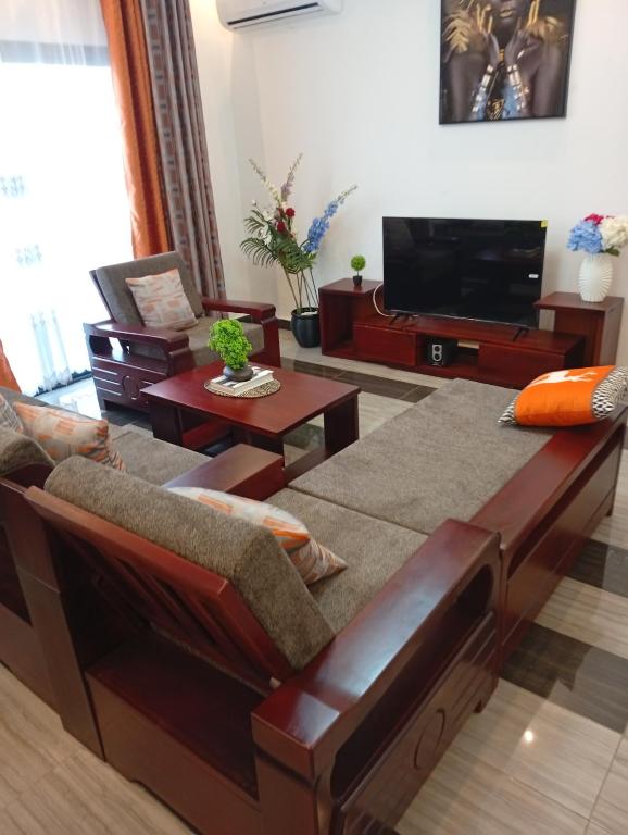 a living room with a couch and a flat screen tv at Résidence Prestige KGV Appt 301 in Douala