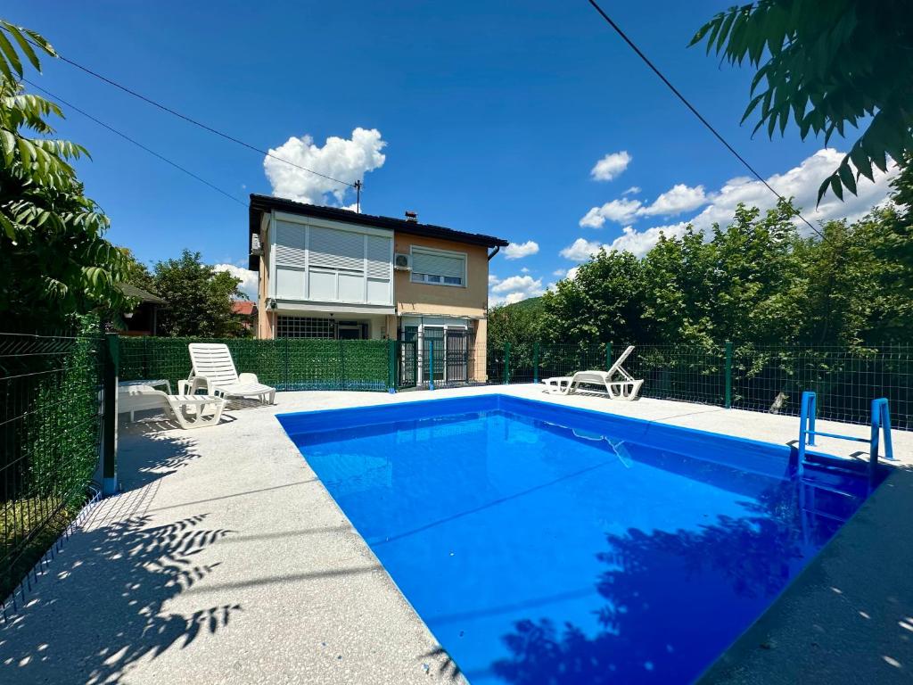 a swimming pool in front of a house at Pool Villa Sarajevo in Sarajevo