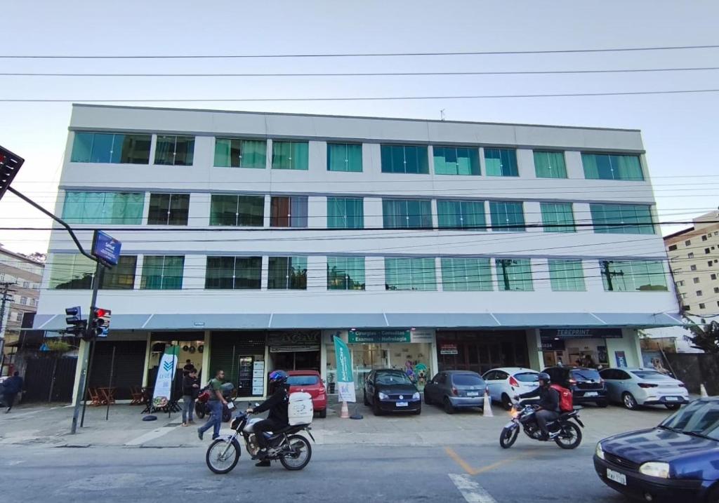 two people riding motorcycles in front of a building at Apartamento na RETA de Teresópolis in Teresópolis