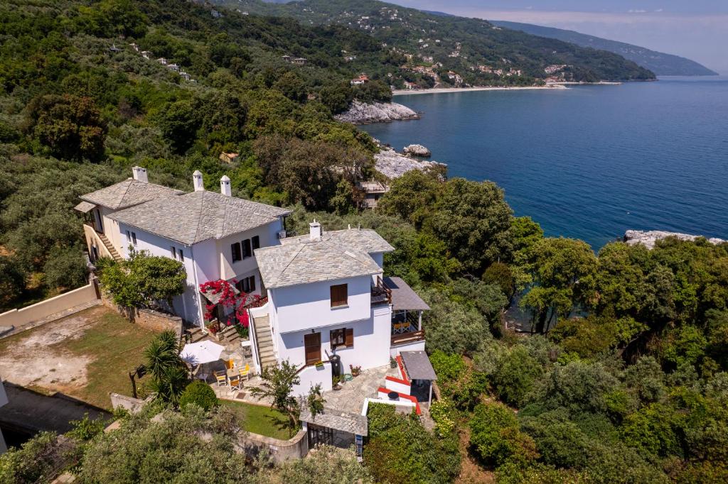 an aerial view of a house on a hill next to the water at Maistros Studios in Damouchari
