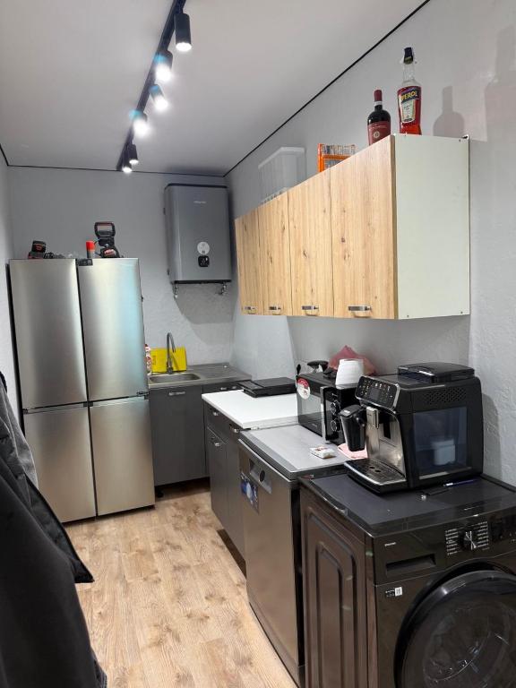 a kitchen with stainless steel appliances and wooden cabinets at Дача на Каролина бугазе in Zatoka