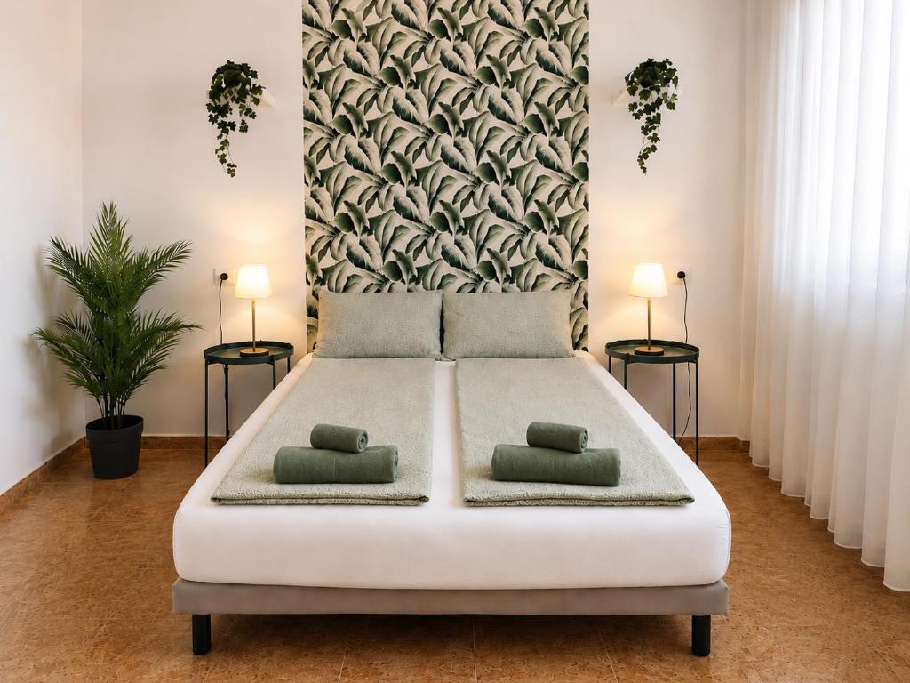 a bedroom with a large white bed with two pillows at Perfectly located apartment with pool in Playa de las Americas
