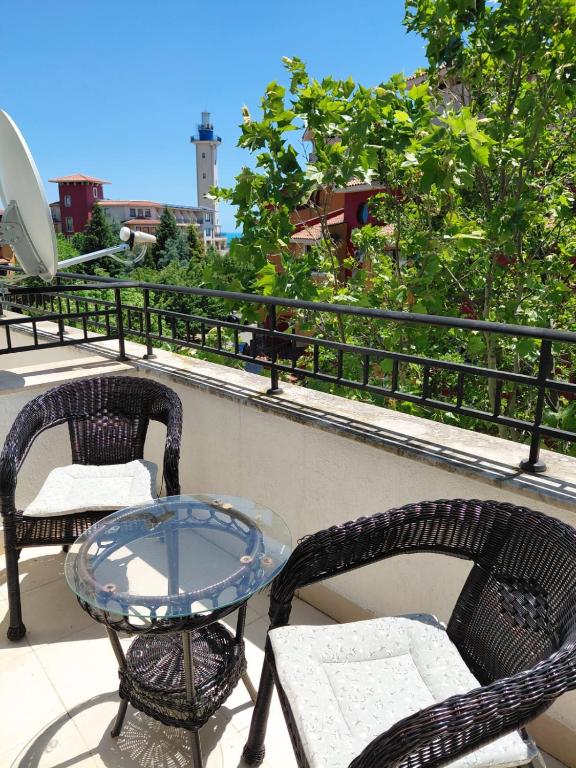 two chairs and a glass table on a balcony at Relaks w Marina Cape 88 in Aheloy