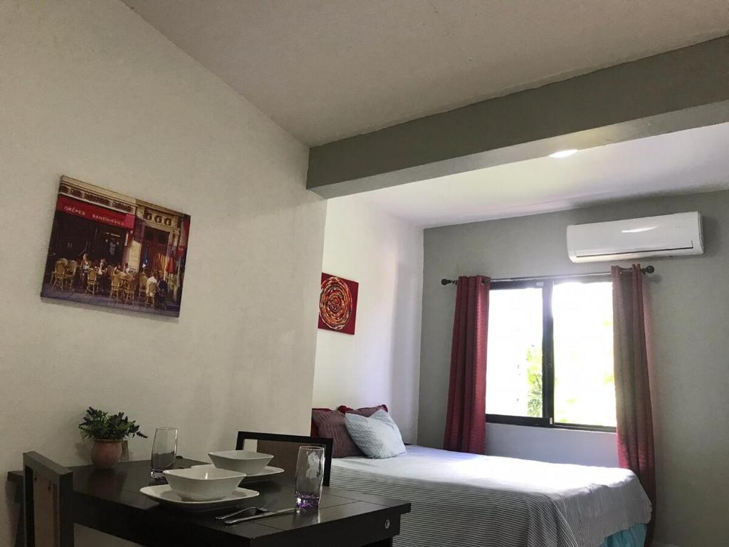 a room with a bed and a table and a window at Estudio #3 a 10 min del malecon in La Paz