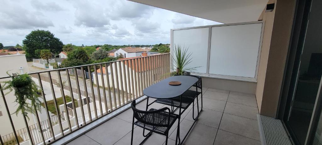 a balcony with a table and two chairs on it at L'Appar-TMN in Challans