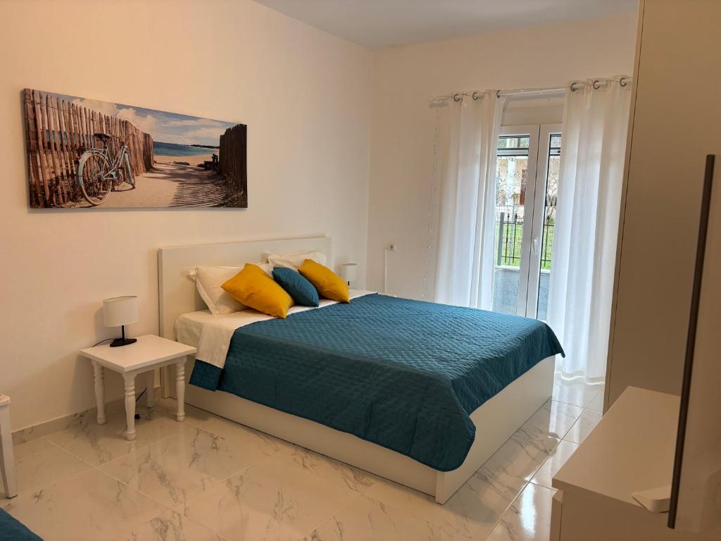 a bedroom with a bed with blue and yellow pillows at Vila Amore in Asprovalta