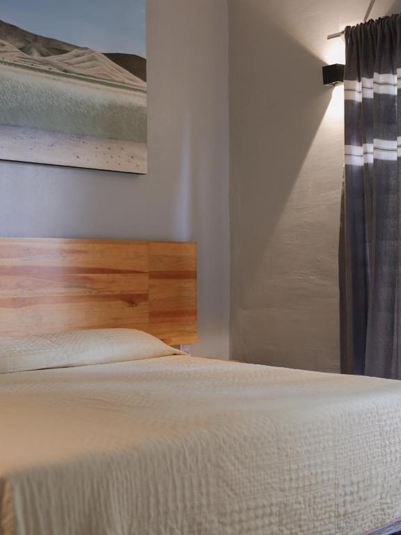 a bedroom with a bed and a painting on the wall at Margarita in Oaxaca City