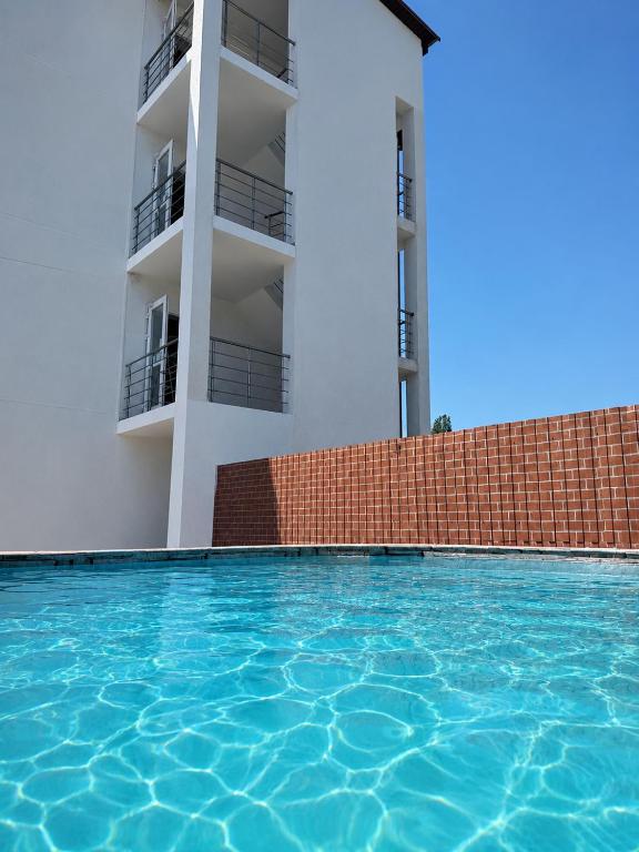a swimming pool in front of a building at Sakura Hotel in Zatoka