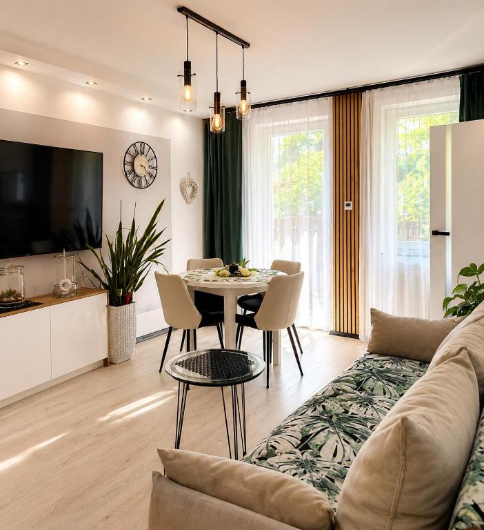 a living room with a couch and a table at Zielone Stablowice Wrocław in Wrocław