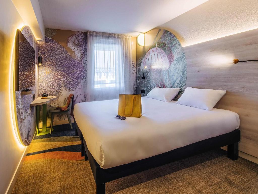 a bedroom with a large bed in a room at ibis Styles Antibes in Antibes