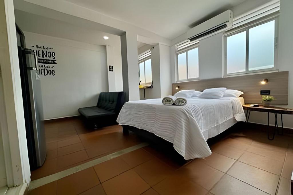 a bedroom with a large white bed and a chair at Our Home San Antonio in Cali