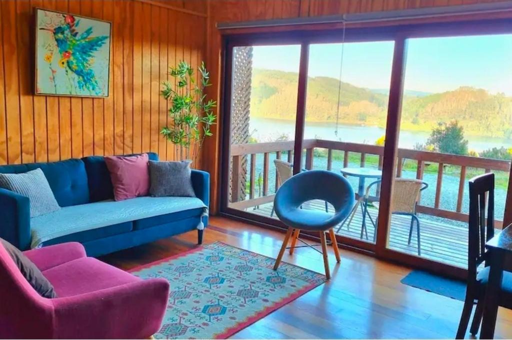 a living room with a couch and a balcony at CostaLoft in Valdivia
