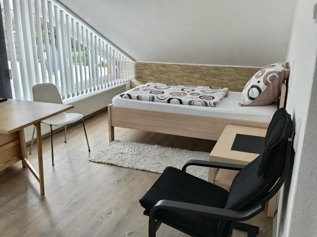 a bedroom with a bed and a desk and a chair at Work & Stay Peine, Parkplatz, WLAN, Küche inkl in Peine