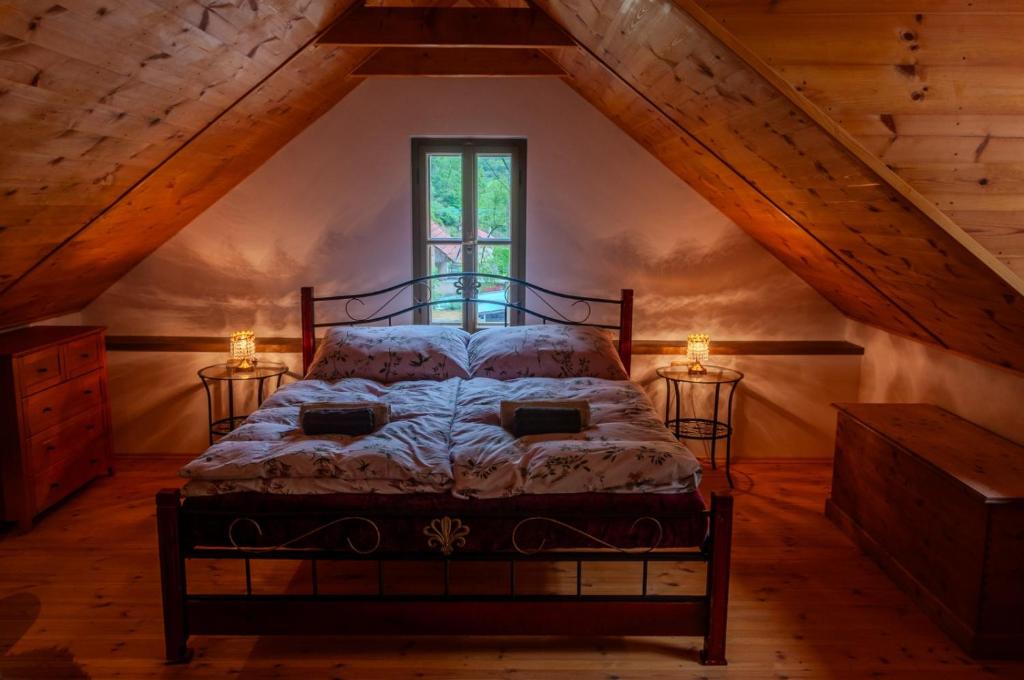 a bedroom with a bed in a attic at Golden Serafín - Romantic apartment below Karlštejn in Karlštejn