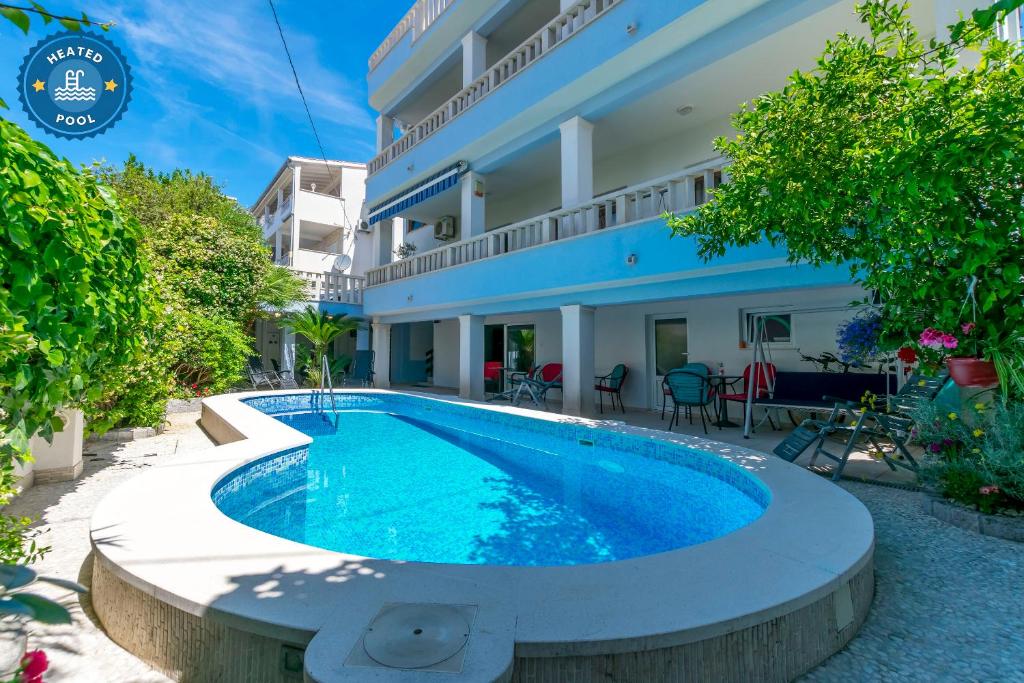 a swimming pool in front of a building at Apartments Adriatic Relax, heated pool, parking place in Duće