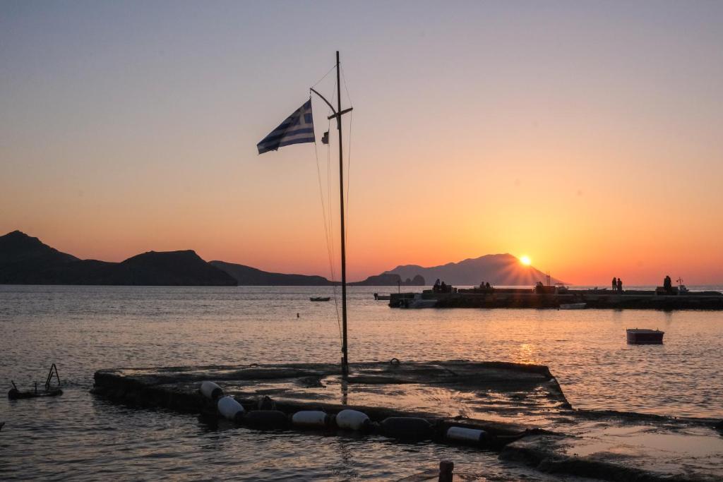 a flag on a dock in the water at sunset at Rota in Klima