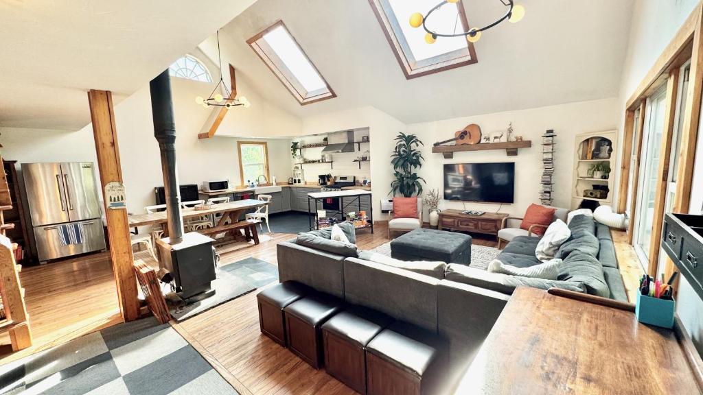 a large living room with a couch and a tv at Cheerful 3-bedroom cabin with mountain view in East Jewett