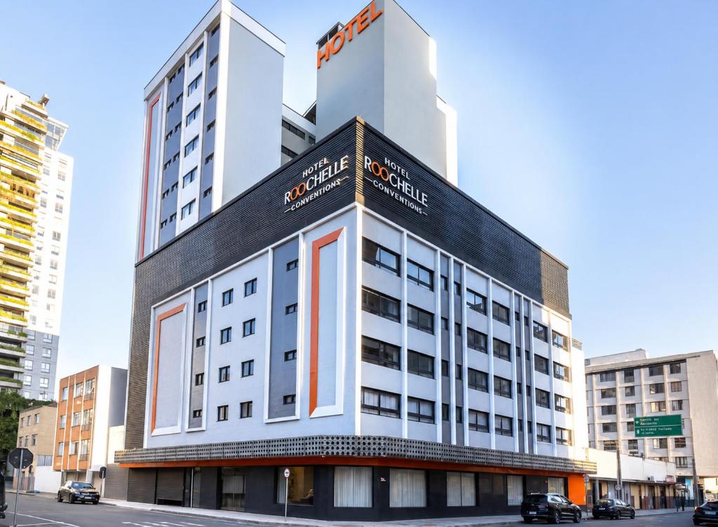 a building with a sign on the side of it at Hotel Roochelle Convention By Nobile in Curitiba