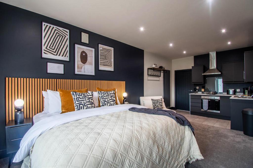 a bedroom with a large bed and a kitchen at The Mariner's Rest Aparthotel in Cleethorpes