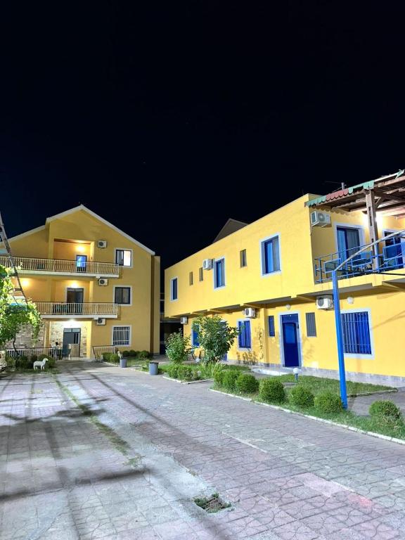 an empty street in front of two buildings at night at Hotel Parking Pika in Shëngjin