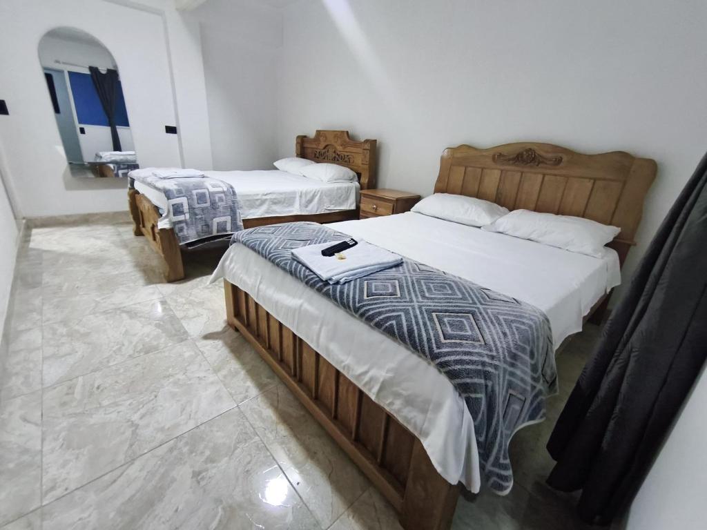 a bedroom with two beds at Hotel El Empedrado in Popayan