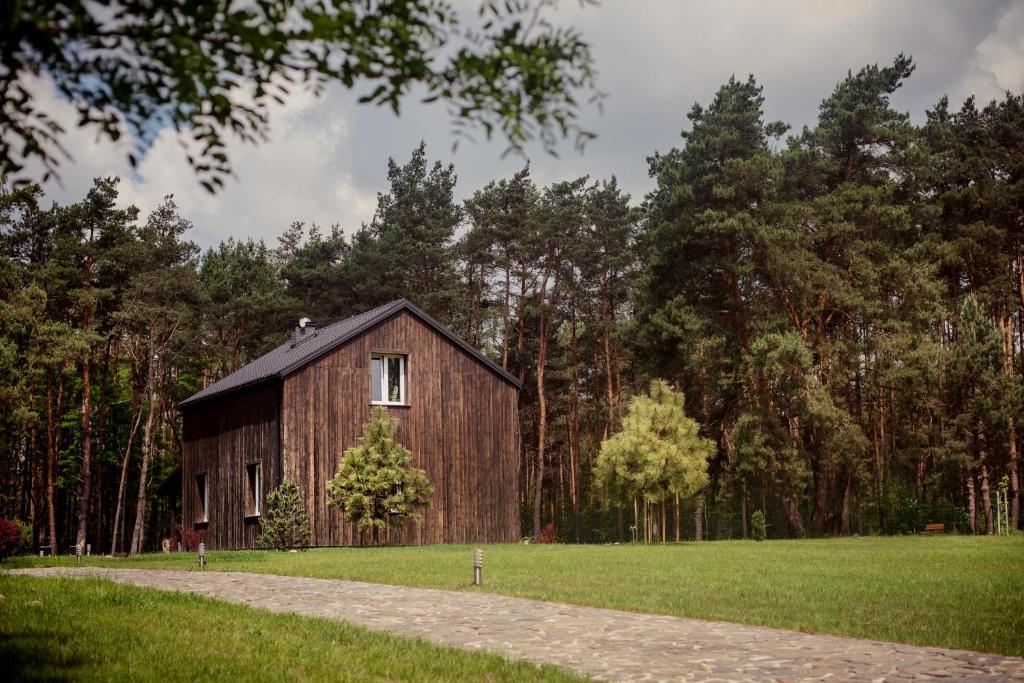 a wooden barn in the middle of a field at Dom pod Niebem in Lucimia