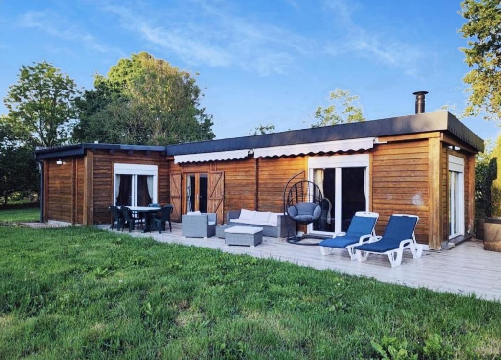 a log cabin with chairs and a patio at Le Châlet Nature de Lieurey in Lieurey