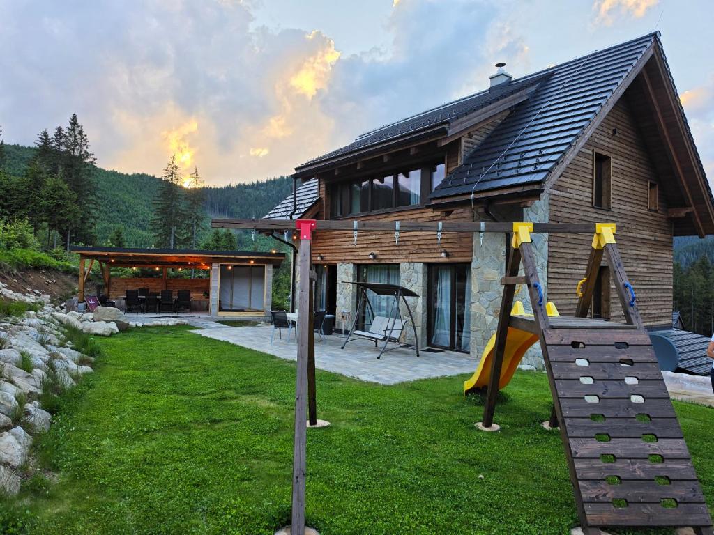 a log cabin with a slide and a playground at Hillview Jasná Chalet in Belá