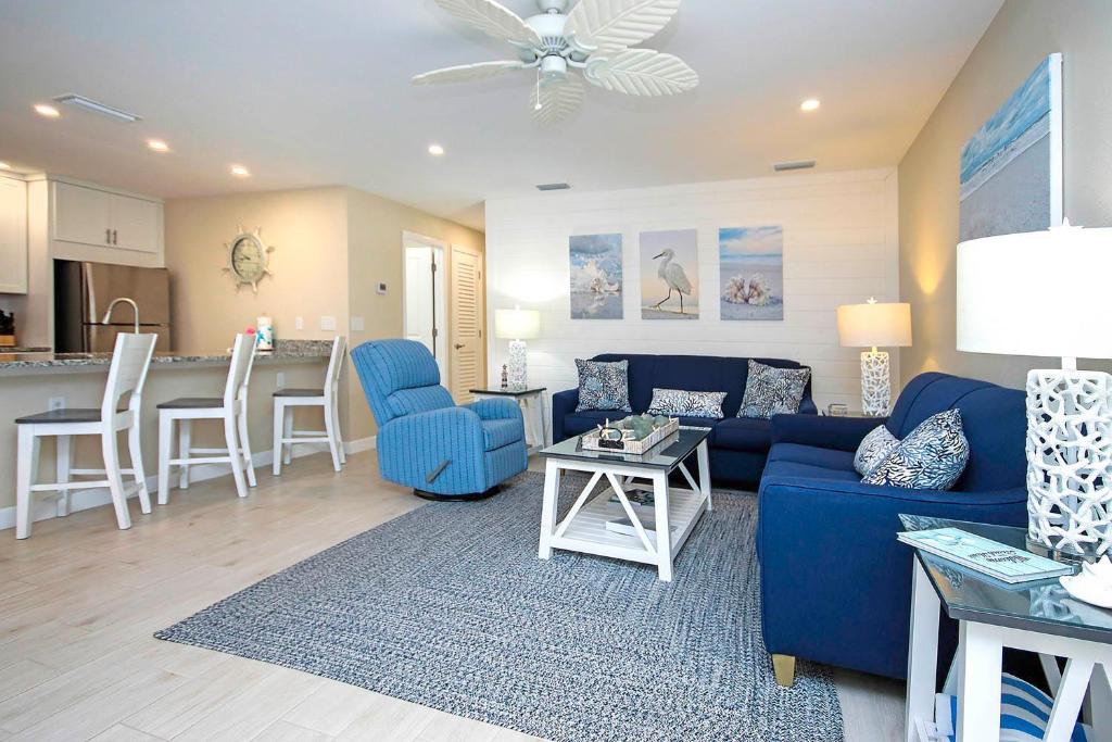 a living room with a blue couch and a kitchen at Sanibel Arms West Unit A1 in Sanibel