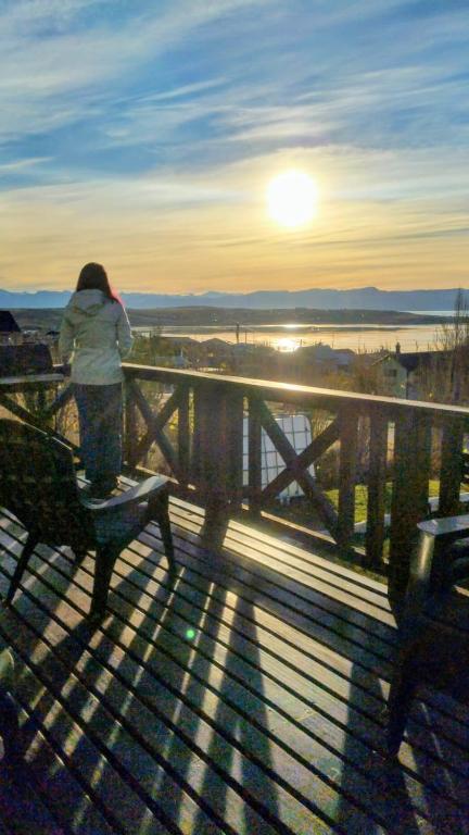 a person standing on a bench watching the sunset at CABAÑA M&M in El Calafate