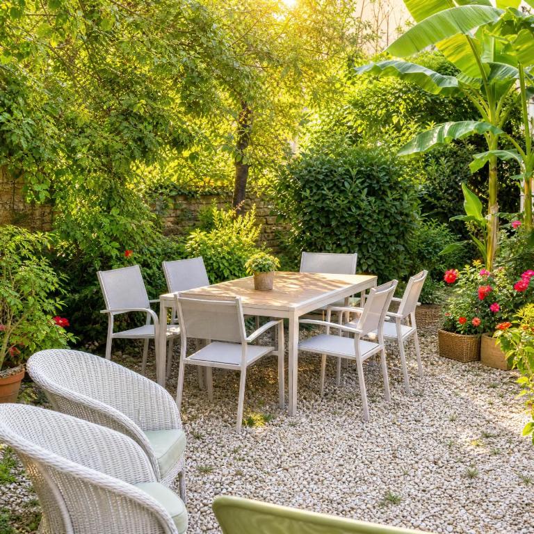 a wooden table and chairs in a garden at Le Jeu de Paume - Bail Partner in Mailly-le-Château