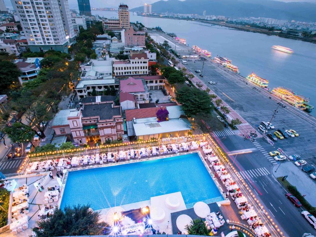 An elevated evening view of a rooftop pool overlooking the riverfront city.