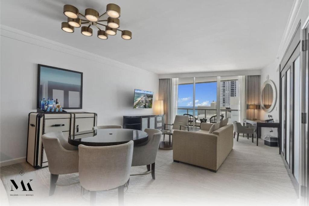 a living room with chairs and a dining room at Fontainebleau 2Dbl Queen Bed City plus Ocean View in Miami Beach