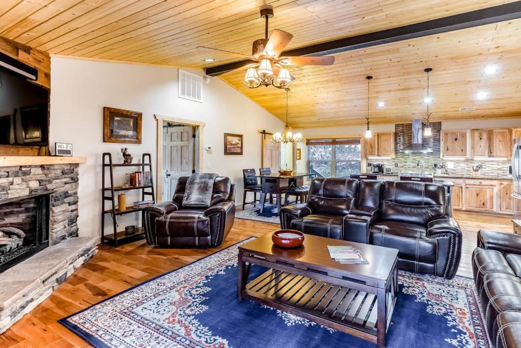 a living room with leather furniture and a fireplace at Little Bear in Maggie Valley