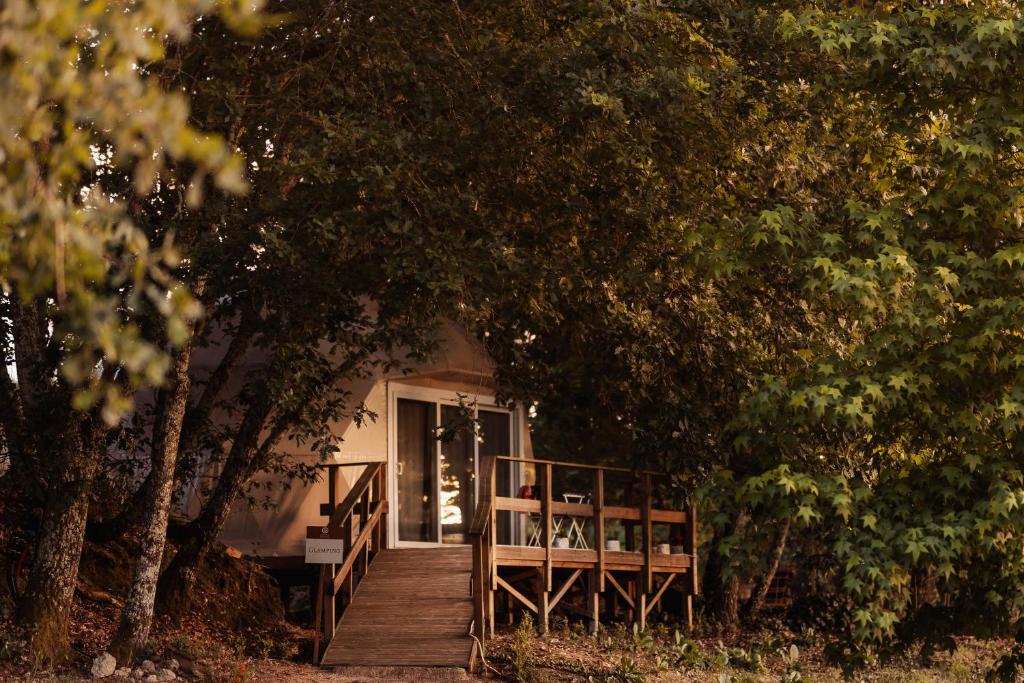 a wooden walkway leading to a house with a porch at Manteiros Glamping in Canas de Senhorim