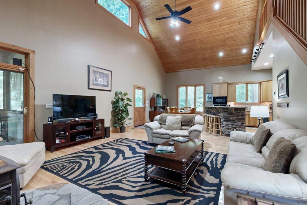 a living room with couches and a flat screen tv at Rhymer Haven in Juno