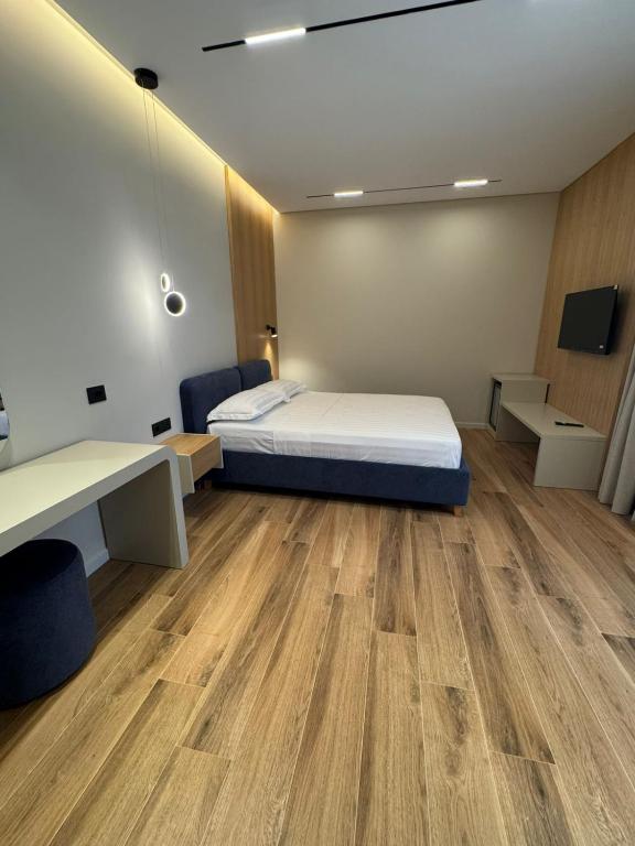 a room with a bed and a desk and a table at EFFÉI Boutique Hotel in Sarandë