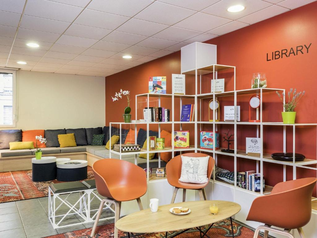 a library with chairs and a table in a room at Aparthotel Adagio Access Paris Asnières in Asnières-sur-Seine
