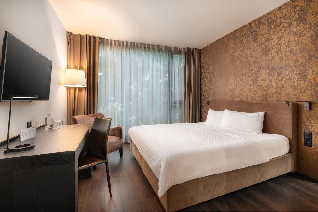 a hotel room with a bed and a desk with a computer at b-smart hotel Widnau in Widnau