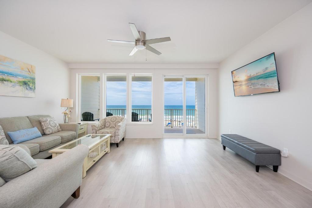 a living room with a couch and a ceiling fan at Sea Glass 305 in Gulf Shores