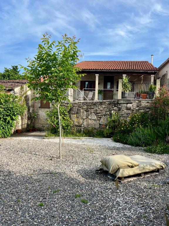 a bed on the ground in front of a house at Casa María da Reza in Ribadavia