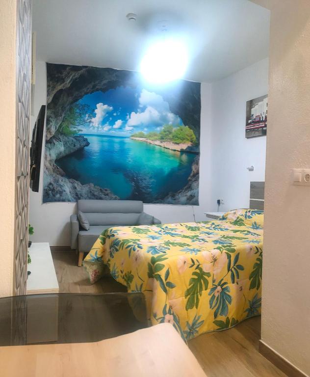 a bedroom with a painting of a river at Apartamento La Cueva silencioso in Algarrobo