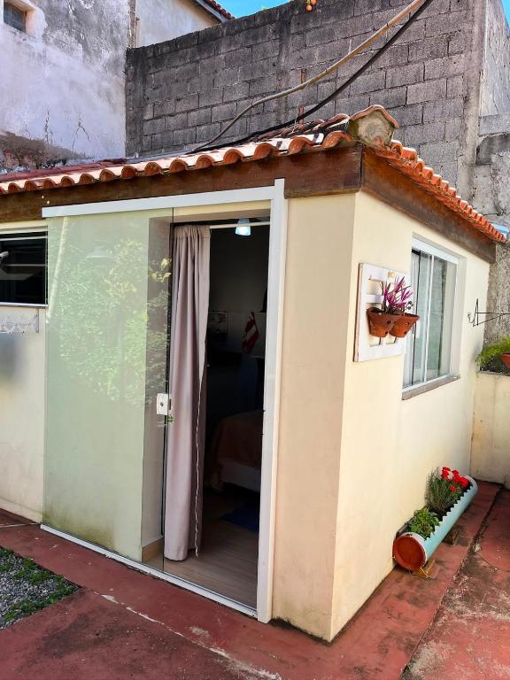 a small shed with a door and a window at Pousada Moradia da Fabi in Bragança Paulista
