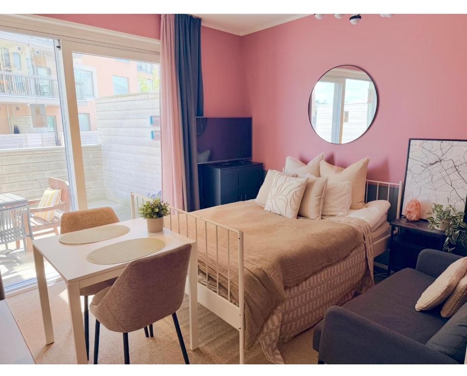 a bedroom with a bed and a table and a chair at The Seabreeze Terrace Apartment in Turku