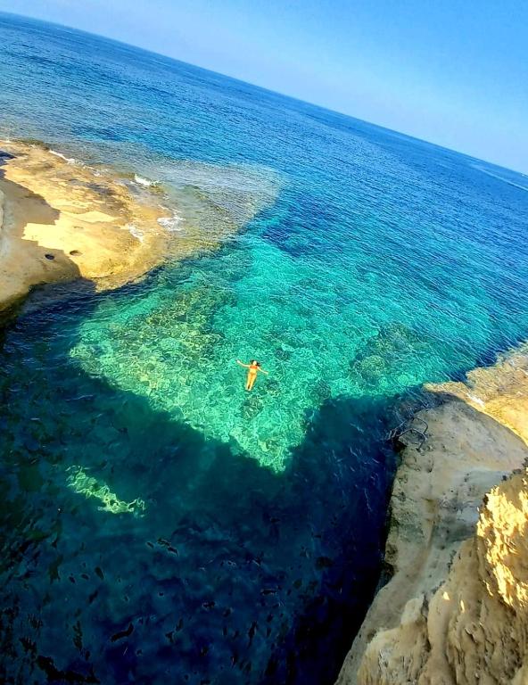a person in the water in the ocean at Del Mar Apartment in Żebbuġ