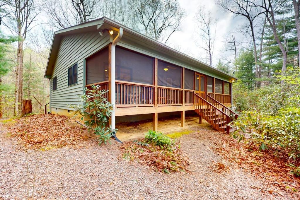 a house in the woods with a large deck at Raven's Respite in Saluda