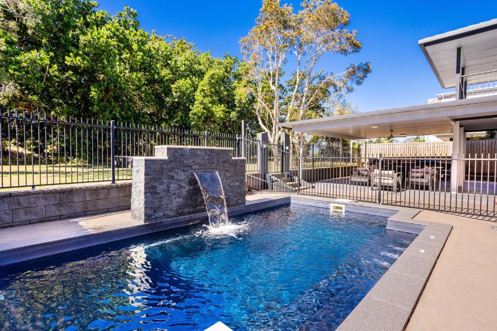 a swimming pool with a fountain in a yard at SeaBreeze On Todd in Yeppoon